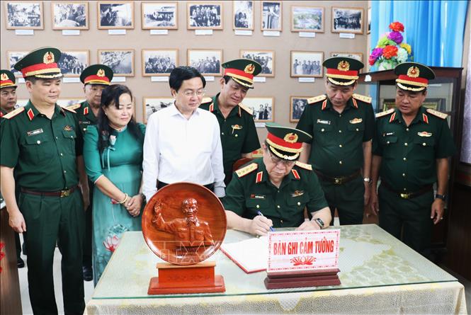 Đại tướng Nguyễn Trọng Nghĩa viết sổ lưu niệm tại Nhà truyền thống Cơ quan Chính trị Quân khu 8, ghi dấu chuyến thăm nhân kỷ niệm 80 năm Ngày truyền thống của cơ quan. Ảnh: Bùi Giang - TTXVN