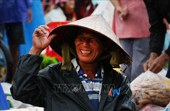 Nhiều hôm trời mưa, những người bán hàng vẫn tươi cười, kiên nhẫn ngồi bên những mẹt hàng giản dị, chờ khách ghé mua. Ảnh: Duy Khương – TTXVN