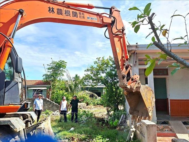 UBND phường Đào Duy Từ huy động máy móc, phương tiện hỗ trợ các hộ dân có đất bị thu hồi, bàn giao mặt bằng thực hiện dự án. Ảnh TTXVN phát  