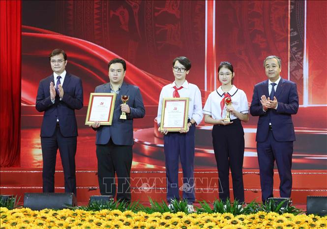 Đại diện tác giả lớn tuổi và nhỏ tuổi nhất nhận Giấy chứng nhận Cuộc thi chính luận về bảo vệ nền tảng tư tưởng của Đảng lần thứ 6. Ảnh: Phương Hoa - TTXVN