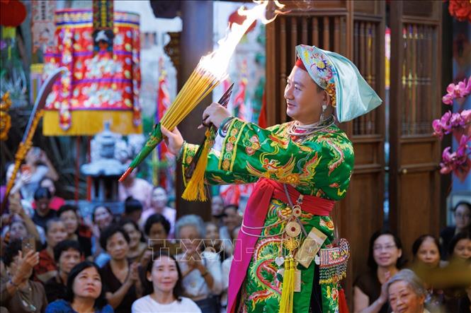 Ánh lửa, màu sắc trang phục cùng chuyển động của người thực hành tạo nên khoảnh khắc giàu tính biểu cảm trong nghi lễ hầu đồng. Các hình thức diễn xướng được thực hiện trong không gian thờ tự, gắn với niềm tin và những quy thức tín ngưỡng được cộng đồng duy trì. Ảnh: Phạm Tuấn Anh - TTXVN