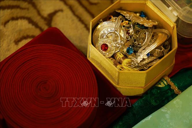 Các món trang sức và phụ kiện như vòng, dây đeo, vật trang trí được sắp xếp trước khi diễn ra nghi lễ hầu đồng. Cùng với khăn áo và đạo cụ, những phụ kiện này góp phần tạo nên diện mạo riêng của thanh đồng trong từng giá hầu. Sự chuẩn bị tỉ mỉ cho thấy nghi lễ hầu đồng bao gồm nhiều công đoạn và đòi hỏi sự am hiểu về trang phục, vật phẩm truyền thống. Ảnh: Phạm Tuấn Anh - TTXVN