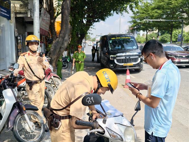 Cán bộ Đội Cảnh sát giao thông đường bộ số 1 (Công an Hà Nội) lập biên bản xử lý trường hợp vi phạm quy định về dừng, đỗ xe tại khu vực phố cổ Hà Nội. Ảnh: Trung Nguyên – TTXVN