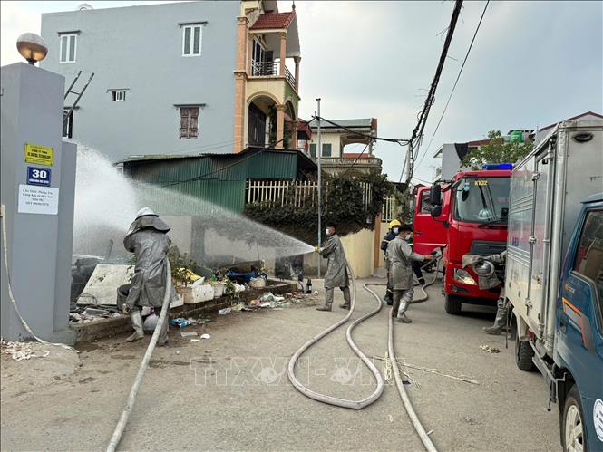 Lực lượng Cảnh sát phòng cháy, chữa cháy và cứu nạn, cứu hộ phun nước làm loãng khí clo tại hiện trường sự cố ở xã Thượng Phúc, Hà Nội. Ảnh: TTXVN phát