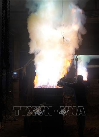 Người thợ đưa than vào lò nấu đồng ở cơ sở trên đường Bùi Thị Xuân, phường Thuận Hóa, thành phố Huế. Ảnh: Nguyên Lý-TTXVN