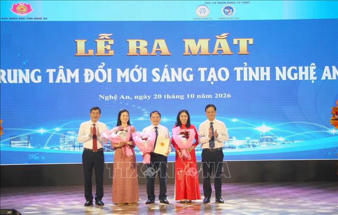 Lãnh đạo tỉnh Nghệ An tặng hoa, trao quyết định thành lập Trung tâm Đổi mới sáng tạo Nghệ An. Ảnh: Văn Tý - TTXVN