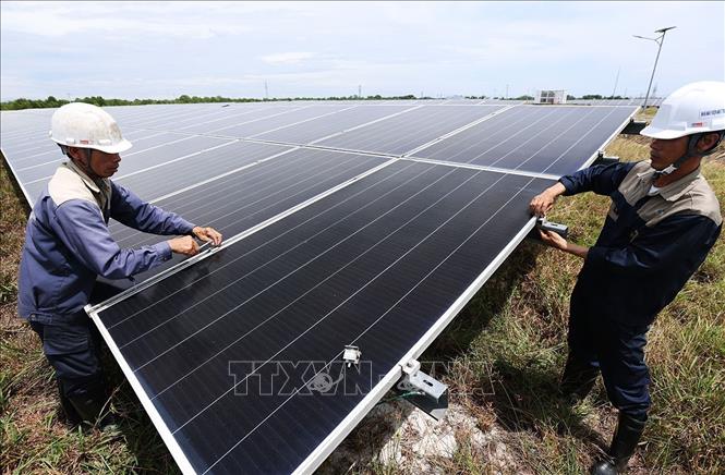 Công nhân kỹ thuật thay thế tấm pin năng lượng mặt trời tại Nhà máy điện mặt trời Gio Thành, tỉnh Quảng Trị. Ảnh: Vũ Sinh - TTXVN 