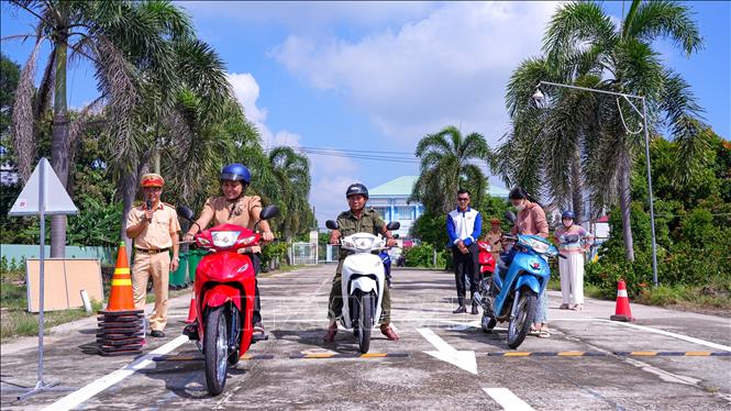 Người dân xã Tân Phú, tỉnh Tây Ninh thực hành điều khiển xe mô tô trên tuyến đường mô phỏng dưới sự hướng dẫn của lực lượng chức năng, nâng cao khả năng quan sát và xử lý tình huống thực tế. Ảnh: Minh Phú - TTXVN
