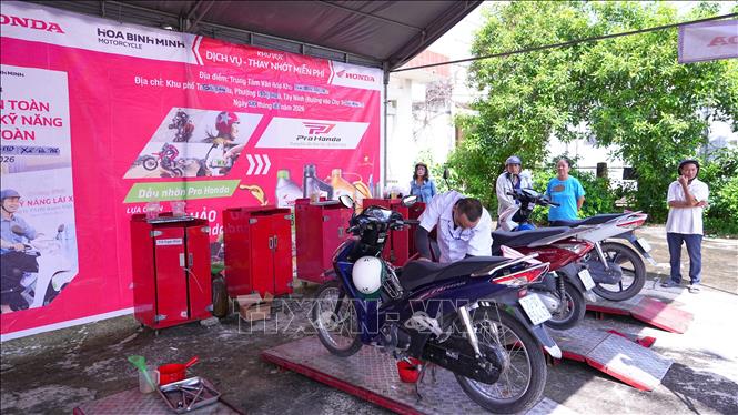 Người dân Tây Ninh được thay nhớt xe mô tô, xe máy miễn phí khi tham giam chương trình. Ảnh: Minh Phú - TTXVN