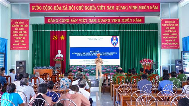 Cán bộ Phòng Cảnh sát giao thông Công an tỉnh Tây Ninh tuyên truyền, phổ biến pháp luật về trật tự, an toàn giao thông và hướng dẫn kỹ năng lái xe an toàn cho người dân tại xã Tân Phú, tỉnh Tây Ninh. Ảnh: Minh Phú - TTXVN