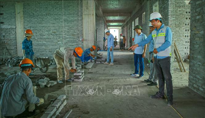 Công nhân thi công tại công trường xây dựng Bệnh viện Da liễu Nam Định. Ảnh: Công Luật - TTXVN