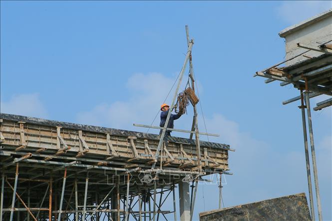 Công nhân vận chuyển sắt thép thi công nhà xử lý chất thải rắn của Dự án. Ảnh: Công Luật - TTXVN