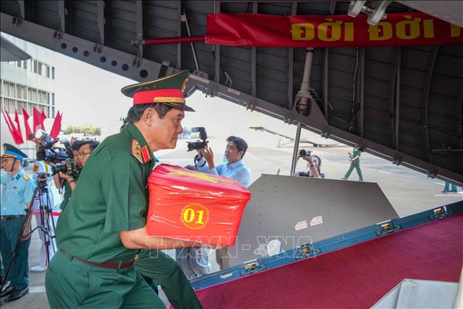 Trung tướng Nguyễn Xuân Dắt, Tư lệnh Quân khu 9 tiến đưa hài cốt liệt sĩ lên máy bay quân sự. Ảnh: Thanh Liêm - TTXVN