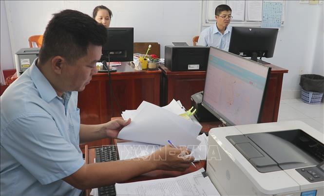 Nhân viên Cảng cá Vàm Láng ở xã Gia Thuận kiểm soát hồ sơ phương tiện, sản lượng thủy sản bốc dỡ tại cảng. Ảnh: Hữu Chí - TTXVN