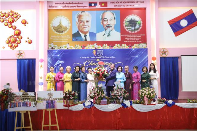 Đại sứ Việt Nam tại Lào Nguyễn Minh Tâm tặng hoa chúc mừng Câu lạc bộ Di sản Áo dài Việt Nam tại Lào. Ảnh: Xuân Tú – PV TTXVN tại Lào