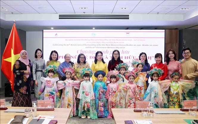 Các đại biểu cùng các bé thiếu nhi tham gia chương  trình diễn áo dài. Ảnh: Xuân Khu - TTXVN 
