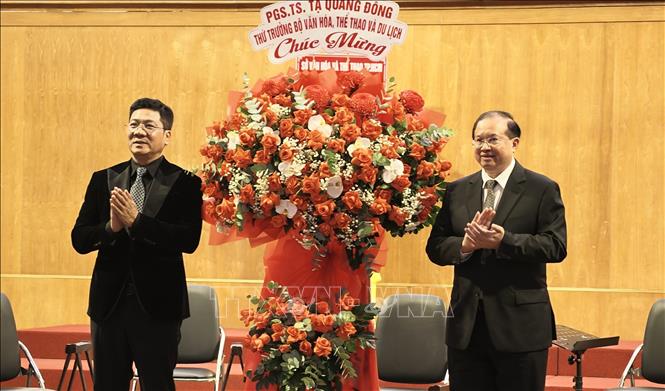 Thứ trưởng Bộ Văn hoá, Thể thao và Du lịch Tạ Quang Đông tặng hoa chúc mừng Ban Tổ chức Liên hoan. Ảnh: Hữu Duyên - TTXVN
