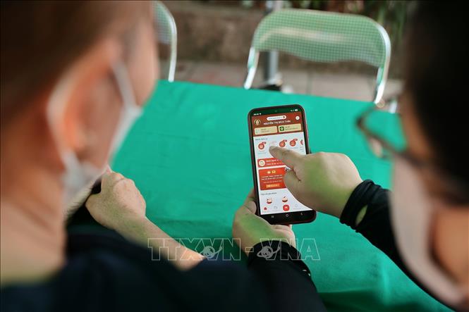 Khu vực hỗ trợ người dân tích hợp Sổ sức khỏe điện tử trên ứng dụng VneID tại điểm khám sức khoẻ phường Lưu Kiếm (Hải Phòng). Ảnh: Minh Quyết - TTXVN