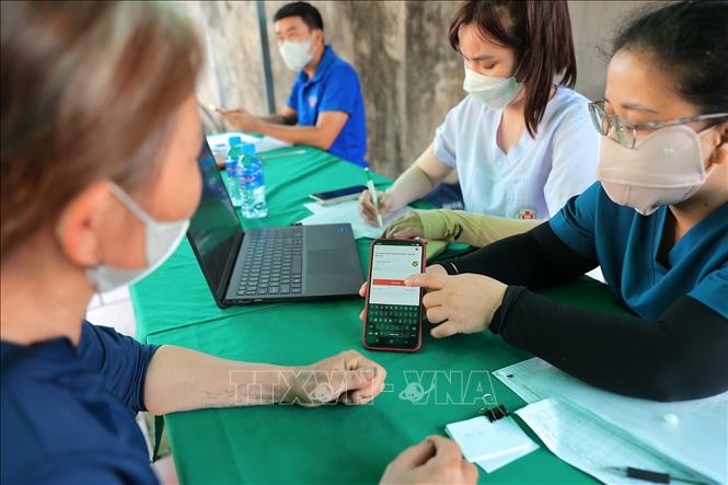 Hướng dẫn người dân kiểm tra thông tin, tra kết qua sổ sức khoẻ điên tử trên ứng dụng VneID. Ảnh: Minh Quyết - TTXVN