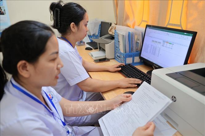 Nhân viên y tế nhập thông tin của người đến khám lên hệ thống, góp phần thúc đẩy chuyển đổi số trong lĩnh vực y tế, nâng cao chất lượng chăm sóc sức khỏe người dân trên địa bàn phường Lưu Kiếm (Hải Phòng). Ảnh: Minh Quyết - TTXVN