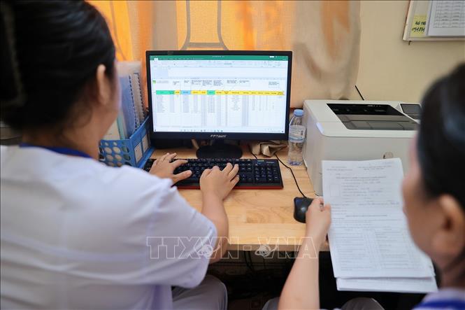 Nhân viên y tế nhập thông tin của người đến khám lên hệ thống, góp phần thúc đẩy chuyển đổi số trong lĩnh vực y tế, nâng cao chất lượng chăm sóc sức khỏe người dân trên địa bàn phường Lưu Kiếm (Hải Phòng). Ảnh: Minh Quyết - TTXVN