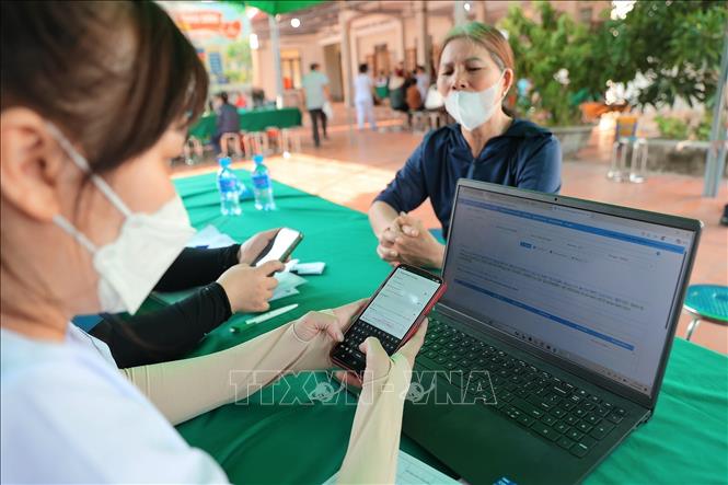 Khu vực hỗ trợ người dân tích hợp Sổ sức khỏe điện tử trên ứng dụng VneID tại điểm khám sức khoẻ phường Lưu Kiếm (Hải Phòng). Ảnh: Minh Quyết - TTXVN