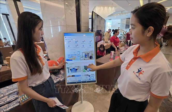 Doanh nghiệp giới thiệu các app điện tử cung ứng các dịch vụ xây dựng, dịch vụ việc làm để phục vụ người dân tại hội thảo. Ảnh: Trần Lê Lâm - TTXVN 