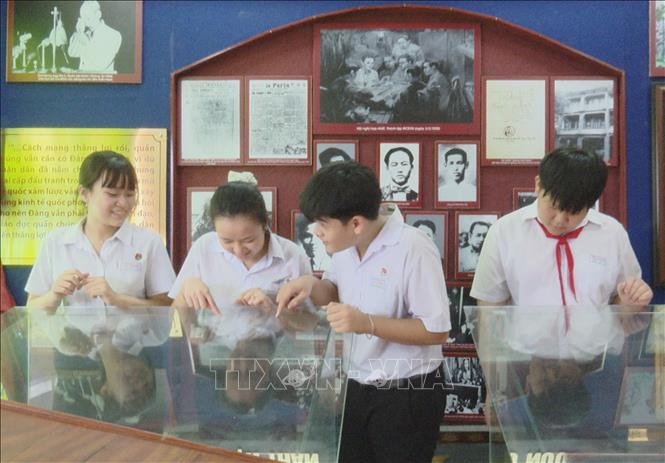 Học sinh xem tư liệu về cuộc đời và sự nghiệp của Bác Hồ tại Di tích cấp tỉnh Phủ thờ Hồ Chủ tịch ở xã Thanh Hưng, tỉnh Đồng Tháp. Ảnh: Hữu Chí - TTXVN