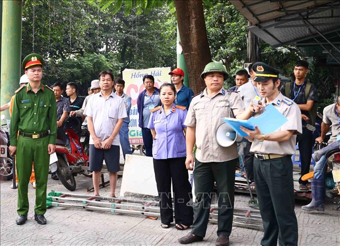 Cán bộ Phòng Thi hành án dân sự khu vực 8 - Phú Thọ công bố quyết định cưỡng chế thi hành án dân sự tại phường Xuân Hòa. Ảnh: Hoàng Hùng - TTXVN