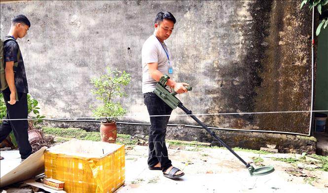 Lực lượng chức năng dò tìm vật liệu nổ tại khu vực cưỡng chế thi hành án dân sự ở phường Xuân Hòa. Ảnh: Hoàng Hùng - TTXVN