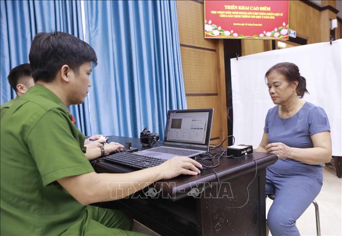 Thân nhân liệt sĩ được lấy dấu vân tay và chụp ảnh để phục vụ công tác xác định danh tính liệt sĩ. Ảnh: Hoàng Hùng - TTXVN