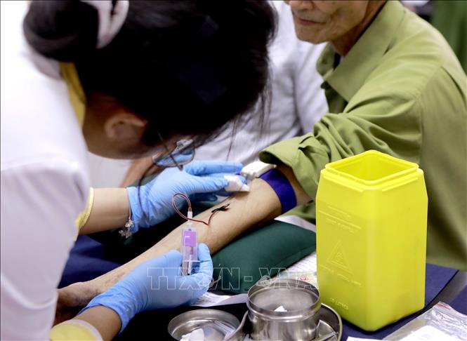 Kỹ thuật viên lấy mẫu máu thân nhân liệt sĩ phục vụ công tác đối chiếu ADN, xác định danh tính liệt sĩ. Ảnh: Hoàng Hùng - TTXVN