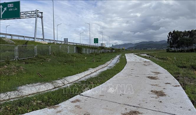 Đường gom dân sinh và kênh mương được xây dựng xung quanh cao tốc. Ảnh: Tường Quân - TTXVN