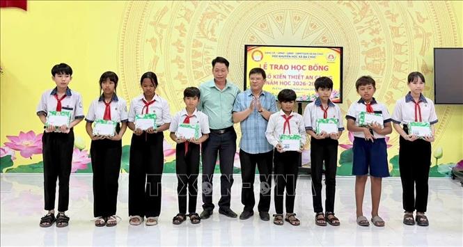 Lãnh đạo xã Ba Chúc, An Giang trao học bổng “Tiếp bước đến trường” cho học sinh có hoàn cảnh khó khăn, nỗ lực vươn lên trong học tập. Ảnh: Thanh Sang – TTXVN