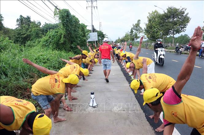 Các vận động viên của đội ghe Ngo thực hiện các bài tập khởi động trước khi bước vào buổi tập luyện chính thức dưới nước. Ảnh: Trung Kiên - TTXVN