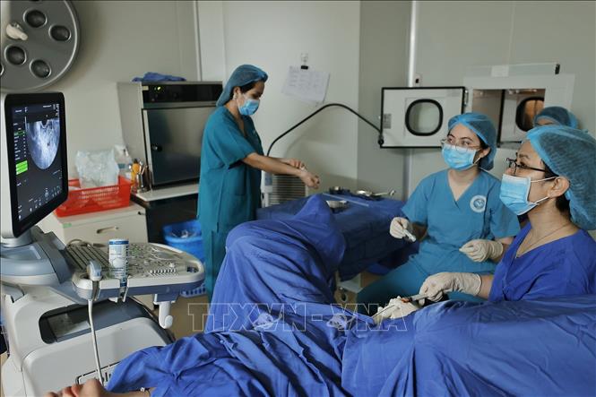 Bác sĩ thực hiện chuyển phôi vào buồng tử cung cho bệnh nhân. Ảnh: Minh Quyết - TTXVN
