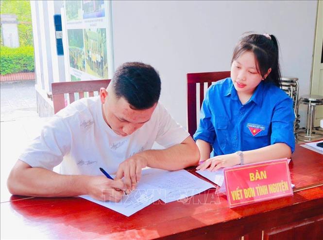 Cán bộ đoàn thanh niên hướng dẫn thanh niên trong độ tuổi thực hiện nghĩa vụ quân sự ở xã Tề Lỗ viết đơn tình nguyện nhập ngũ. Ảnh: Nguyễn Thảo - TTXVN
