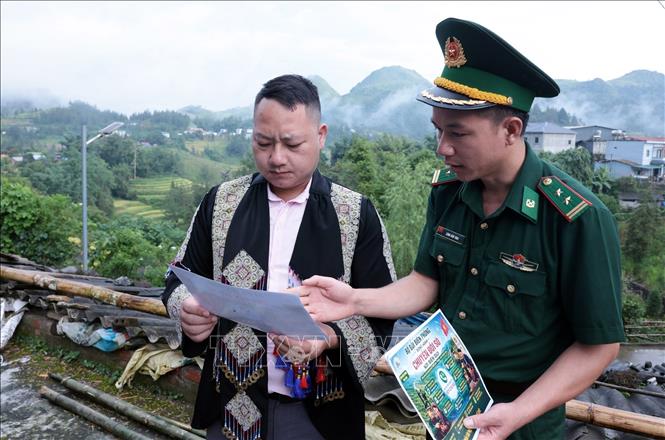 Cán bộ Biên phòng Pha Long, Lào Cai đến tận thôn, bản phát tờ rơi và tuyên truyền pháp luật và tiếp cận nền tảng số. Ảnh: Trần Việt - TTXVN