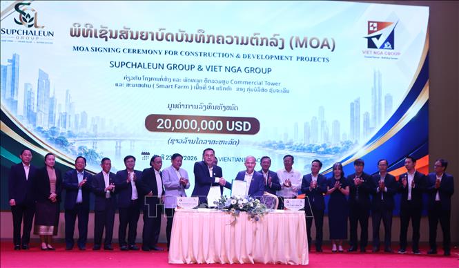 Lãnh đạo hai Tập đoàn trao Biên bản thỏa thuận hợp tác (MOA) và bắt tay chúc mừng sự thành công của Lễ ký kết. Ảnh: Xuân Tú – PV TTXVN tại Lào