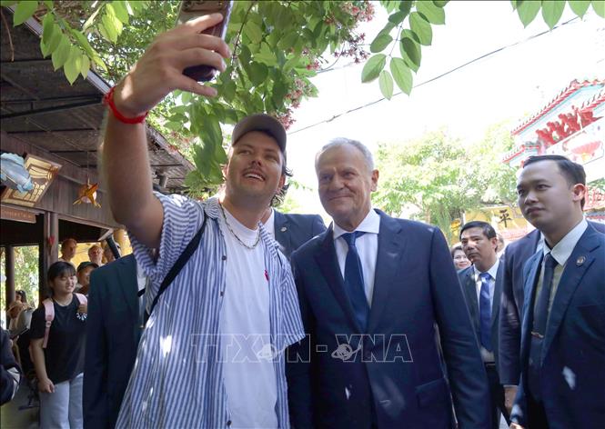 Du khách chụp ảnh cùng Thủ tướng Ba Lan Donald Tusk tại Phố cổ Hội An. Ảnh: Trần Lê Lâm - TTXVN 