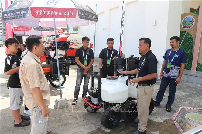 Khách hàng tìm hiểu một thiết bị máy móc phục vụ sản xuất nông nghiệp được trưng bày tại sự kiện. Ảnh: Minh Hưng - PV TTXVN tại Campuchia