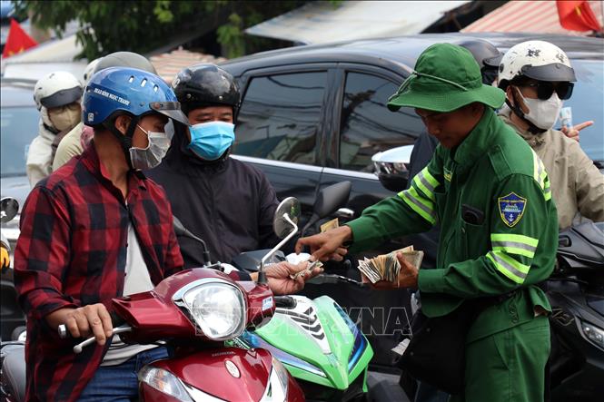 Nhân viên bán vé cho hành khách qua phà Cát Lái. Ảnh: Tiến Lực - TTXVN