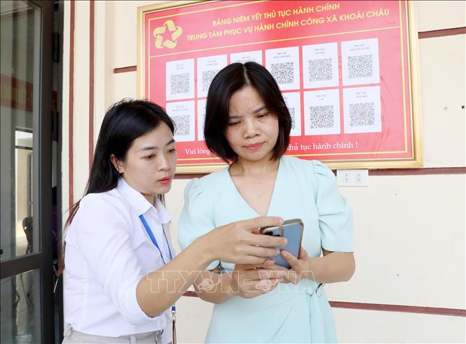 Cán bộ Trung tâm Phục vụ Hành chính công xã Khoái Châu hướng dẫn người dân tra cứu, thực hiện các thủ tục hành chính trên không gian số. Ảnh: Thế Duyệt – TTXVN
