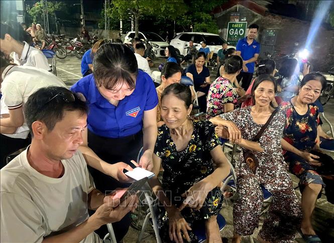 Tổ Công nghệ số cộng đồng xã Khoái Châu hướng dẫn người dân thực hiện các thủ tục hành chính trên không gian số. Ảnh: Thế Duyệt – TTXVN