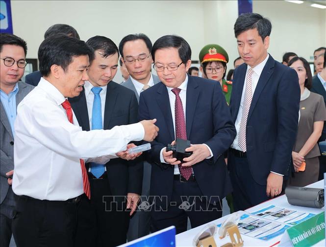 Phó Thủ tướng Hồ Quốc Dũng cùng các đại biểu tham quan các sản phẩm tại Phòng thí nghiệm đóng gói và đo kiểm chip bán dẫn. Ảnh: Hoàng Hiếu - TTXVN