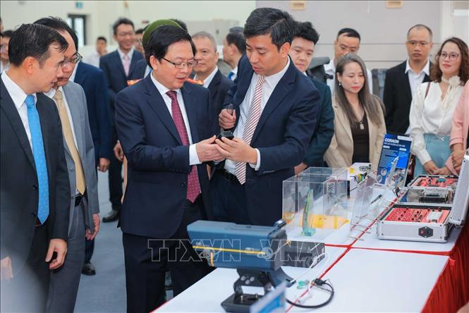 Phó Thủ tướng Hồ Quốc Dũng cùng các đại biểu tham quan các sản phẩm tại Phòng thí nghiệm đóng gói và đo kiểm chip bán dẫn. Ảnh: Hoàng Hiếu - TTXVN