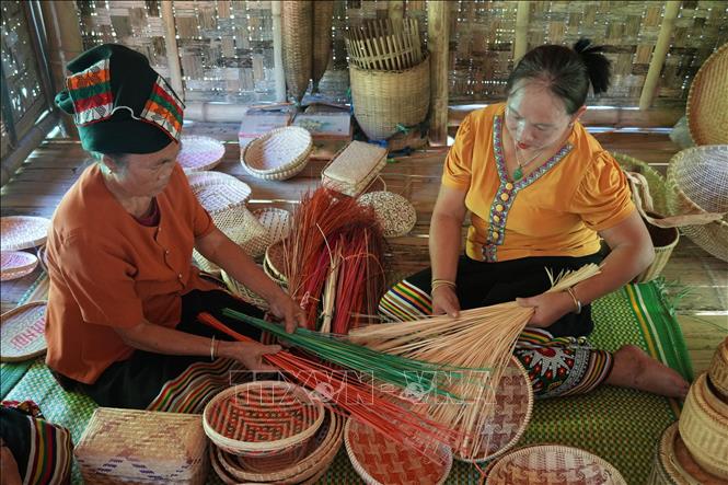 Selecting bamboo strips to weave a product. VNA Photo: Bích Huệ