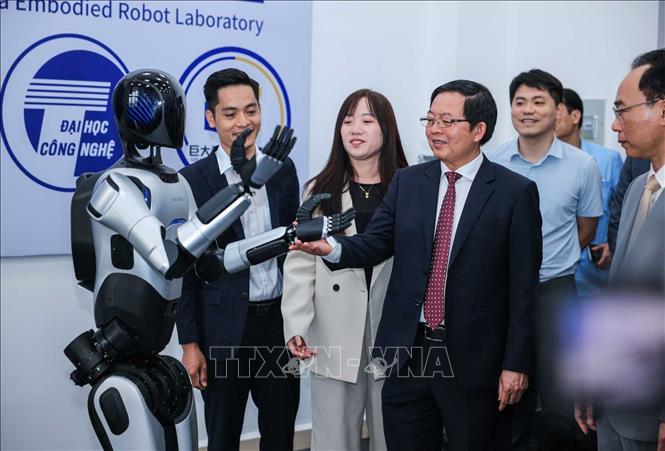 Phó Thủ tướng Hồ Quốc Dũng và các đại biểu tham quan robot tại Trung tâm thực hành tập trung của Trường Đại học Công nghệ. Ảnh: Hoàng Hiếu - TTXVN 