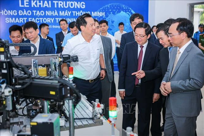 Phó Thủ tướng Hồ Quốc Dũng, Bộ trưởng Bộ Giáo dục và Đào tạo Hoàng Minh Sơn và các đại biểu tham quan máy móc tại Trung tâm thực hành tập trung của Trường Đại học Công nghệ. Ảnh: Hoàng Hiếu - TTXVN 