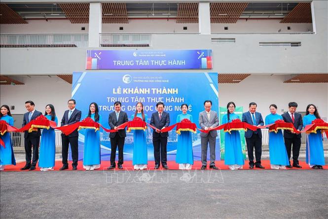 Phó Thủ tướng Hồ Quốc Dũng, Bộ trưởng Bộ Giáo dục và Đào tạo Hoàng Minh Sơn và các đại biểu thực hiện nghi Lễ cắt băng và khánh thành Trung tâm thực hành tập trung của Trường Đại học Công nghệ. Ảnh: Hoàng Hiếu - TTXVN 